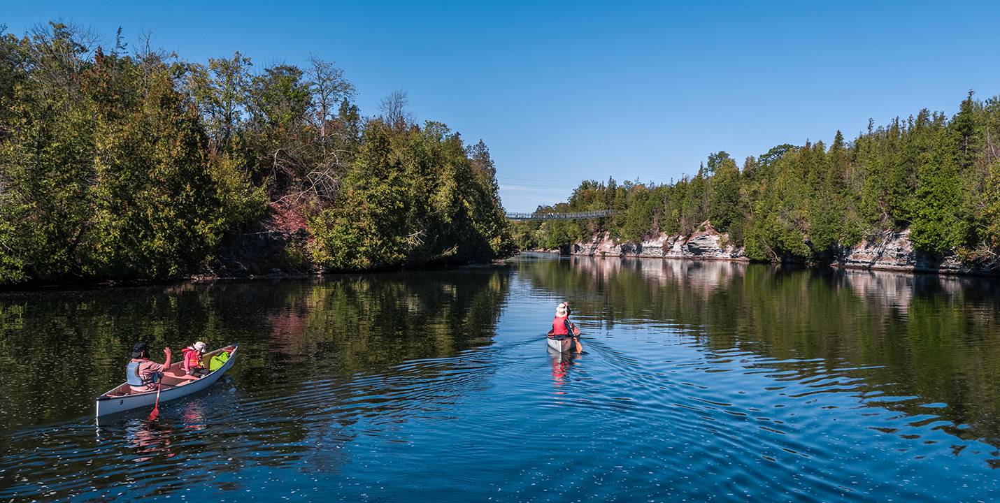Two canoes head towards Ranney Gorge Suspension Bridge