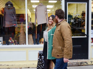 A couple walk past a clothing store's window display
