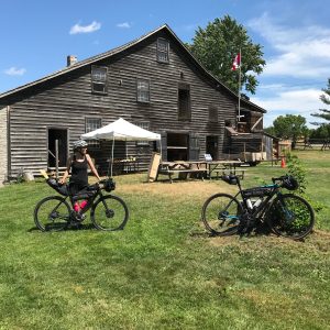 woman standing in front of Hope Mill with a bike bikepacking