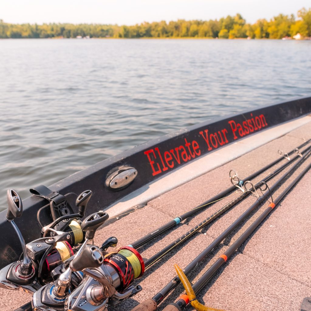 Fishing rods on the bottom of a boat, near the slogan "Elevate Your Passion"