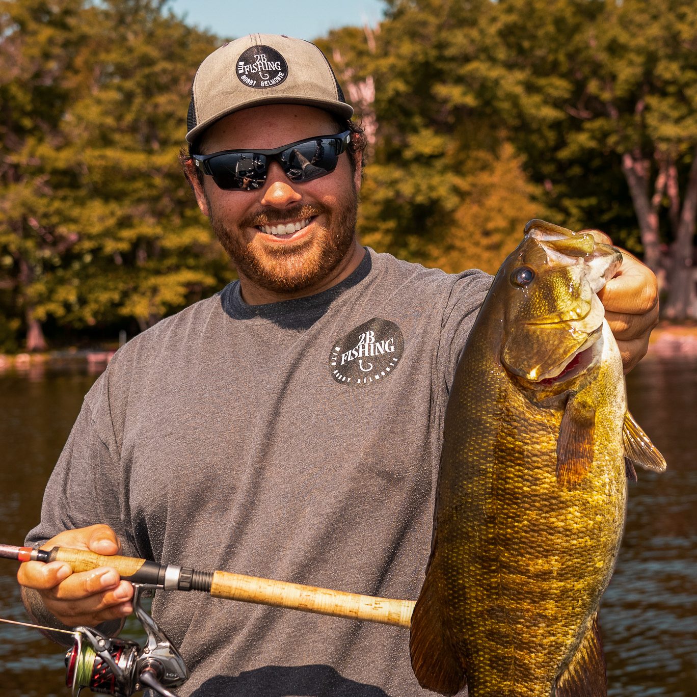 A man holds a largemouth bass towards the camera